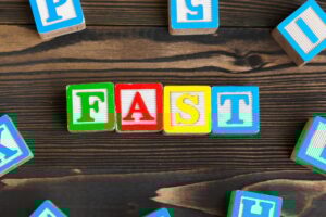 Alphabet blocks ABC on wooden table. Text- fast