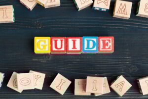 Alphabet blocks ABC on wooden table. Text - Guide