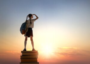 child on the tower of books