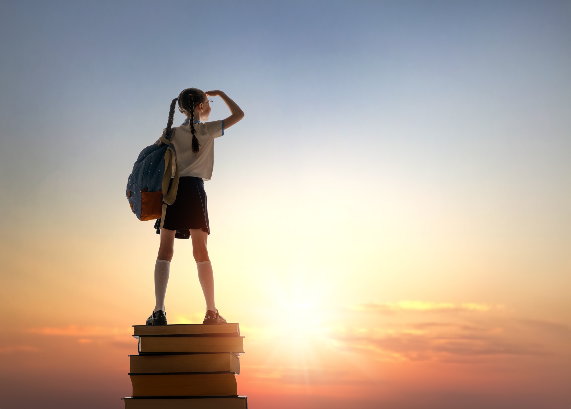child on the tower of books