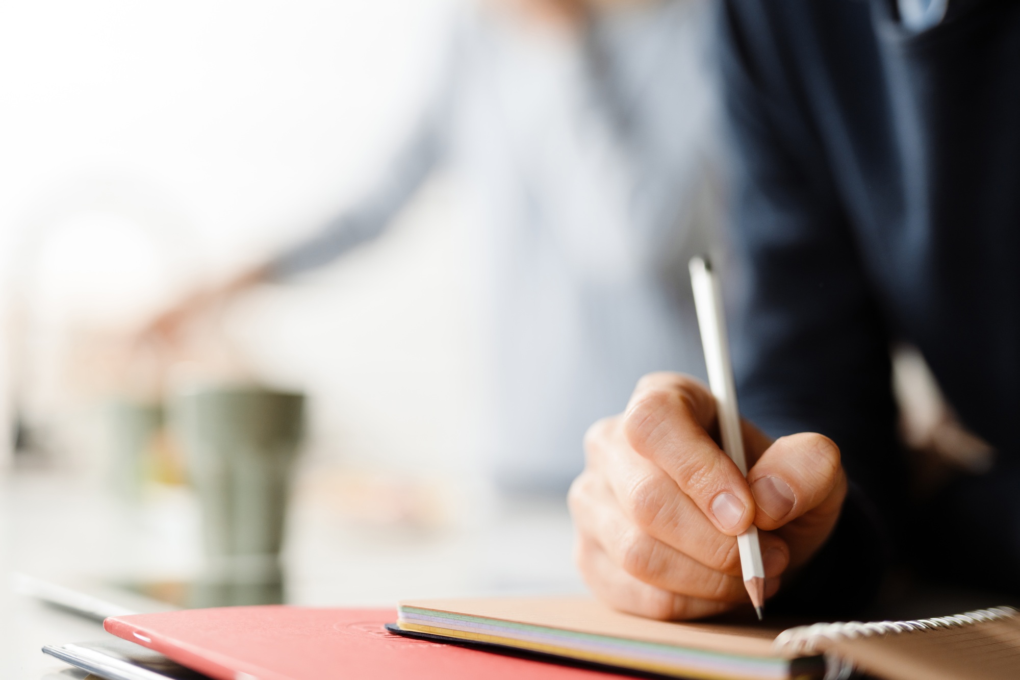 Close up of a male hand writing with pencil