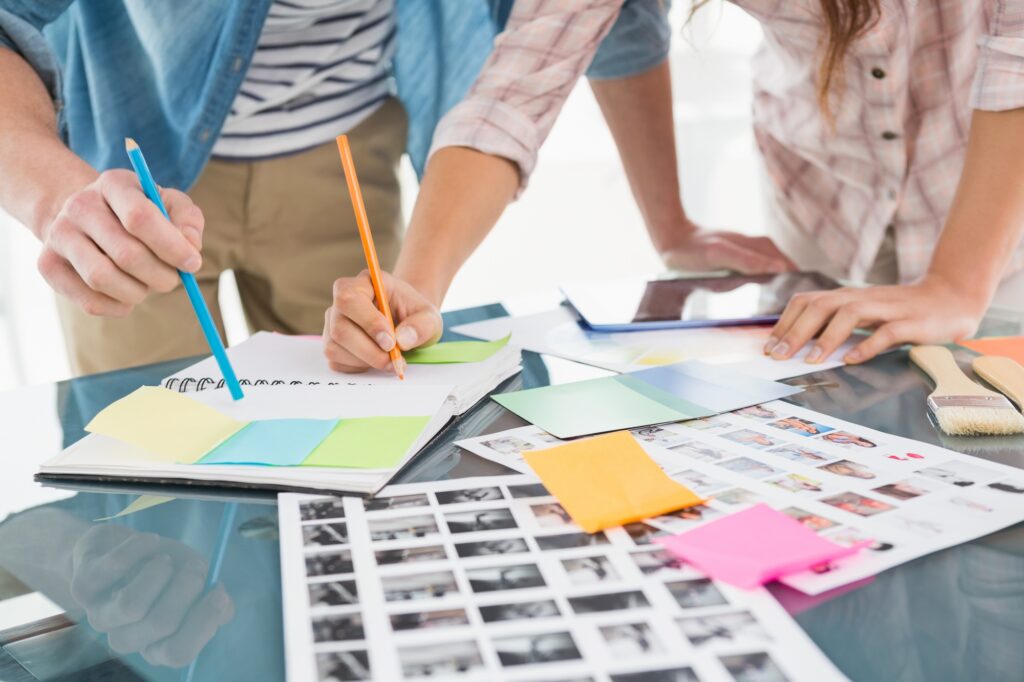 Colleagues writing notes and editing photos in the office