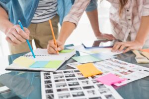Colleagues writing notes and editing photos in the office