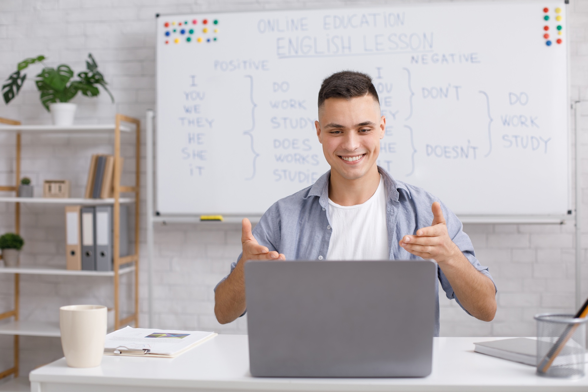 English teacher at home, online practice during COVID-19. Smiling young man rejoices at students