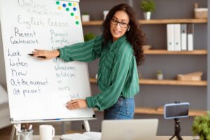 English teacher pointing on board, giving virtual lesson to students
