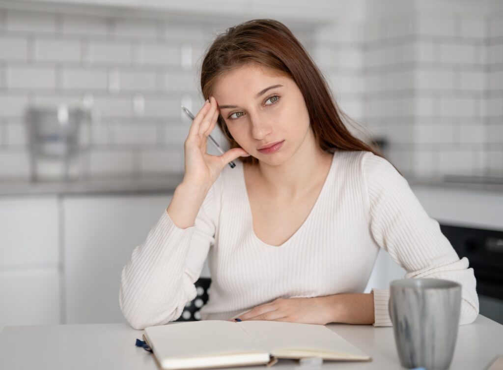 Focused Girl Is Writing In Notebook