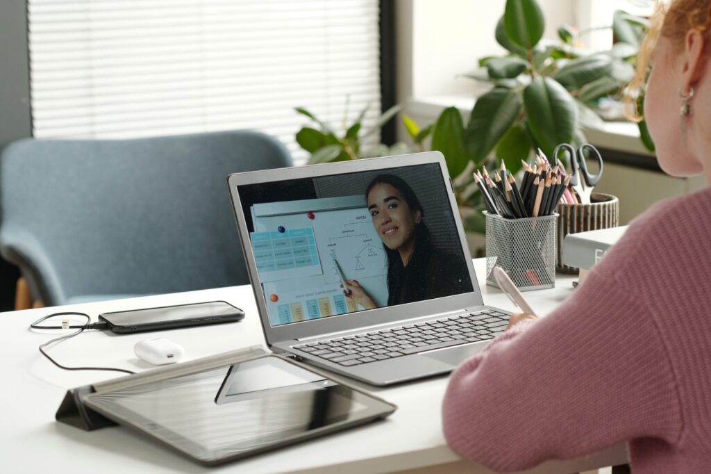 Laptop screen with young successful teacher of English grammar