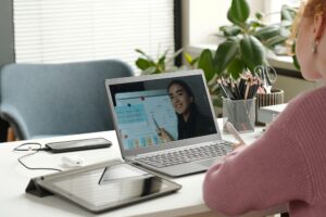 Laptop screen with young successful teacher of English grammar