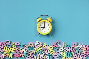 Many multicolored letters and alarm clock. Back To School. School studies, teaching to read.
