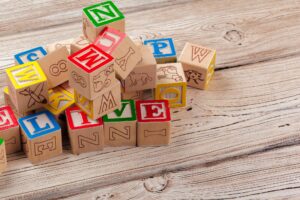 Multicolored wooden toy blocks on wooden background