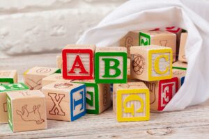 Multicolored wooden toy blocks on wooden background