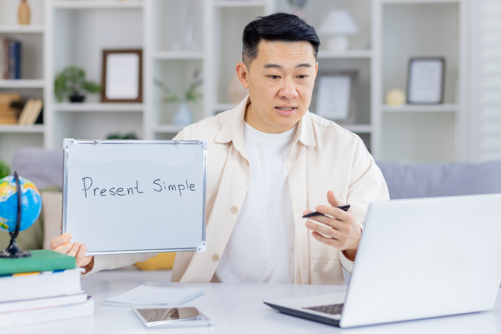 Online English teacher giving a grammar lesson on present simple tense during a virtual class