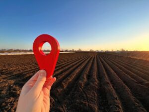 Red location pin on farm field.