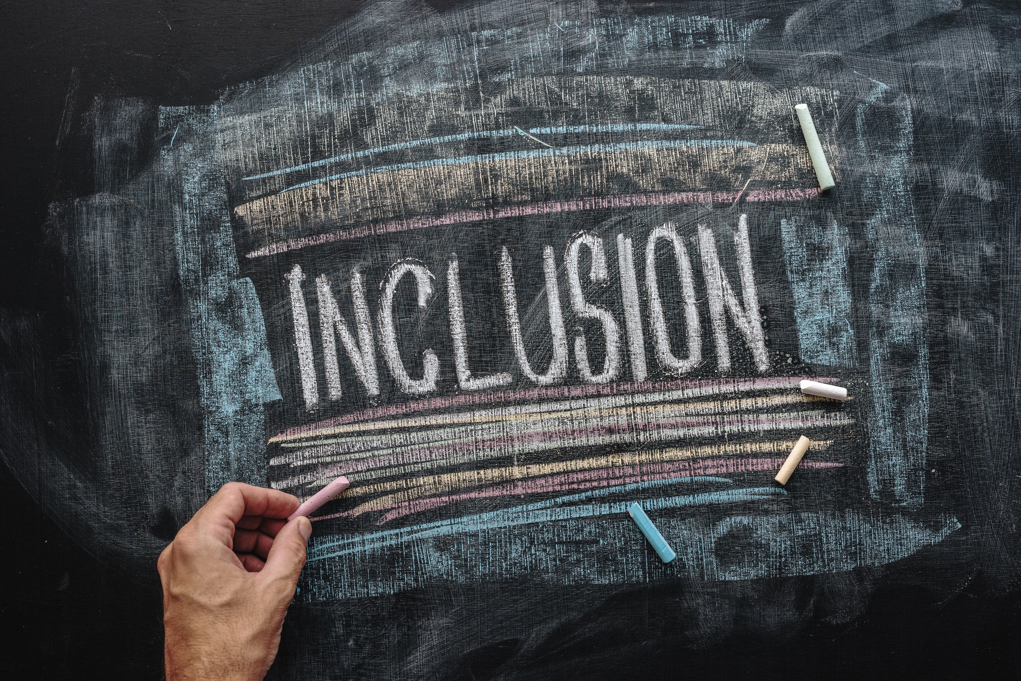 Teacher writing word Inclusion on school blackboard, inclusive e