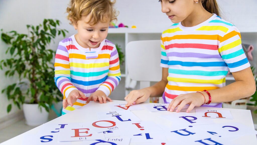 The child learns English letters. Selective focus.
