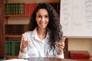Woman sitting at desk, having video chat talking to camera