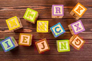 wooden block alphabet lay on wooden floor
