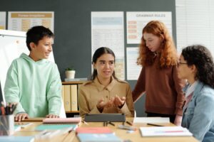 Young confident English teacher explaining new grammar rules to pupils