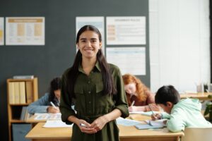 Young professional teacher of English language looking at camera