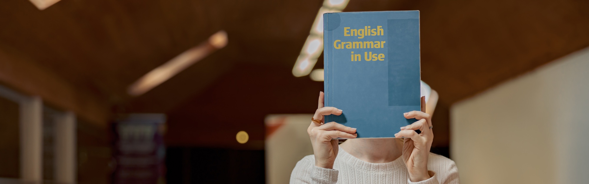Young talented female student studying English Grammar while sit in university library
